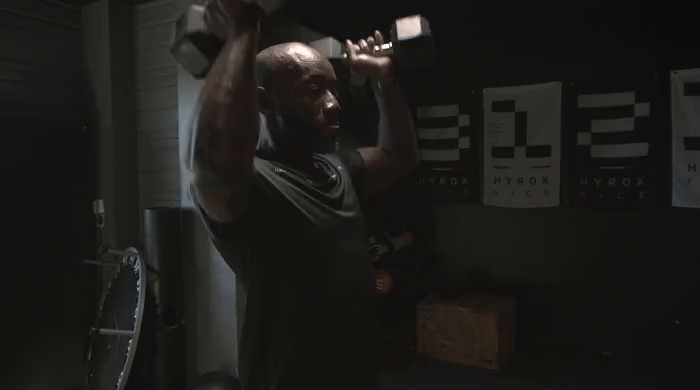Coach EvolveGym démontrant le développé militaire
